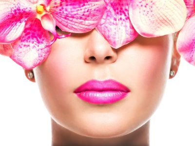 Beautiful face of  woman with bright lipstick on a lips and pink flowers- isolated on white
